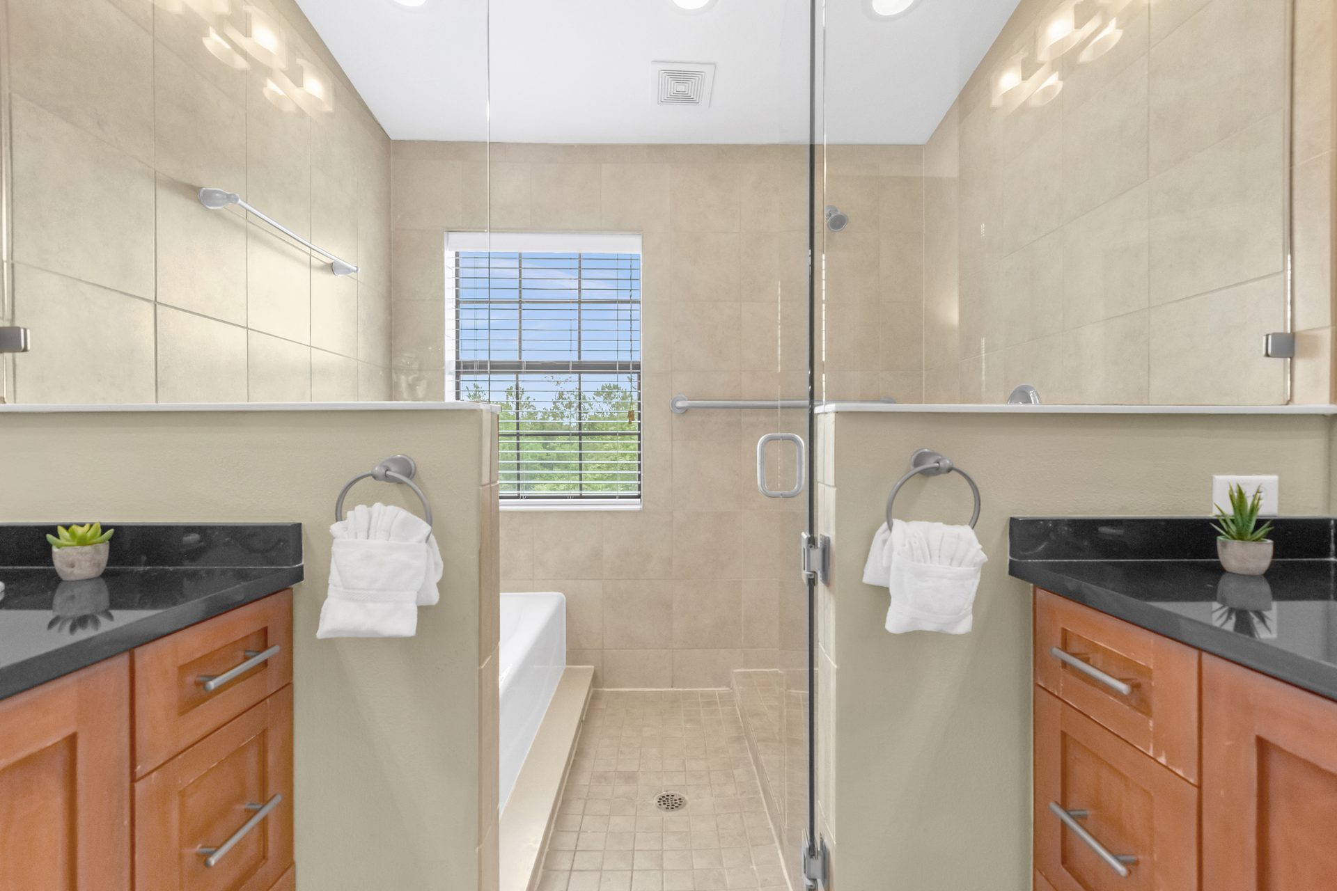 Dual vanity with glass walk-in shower between them